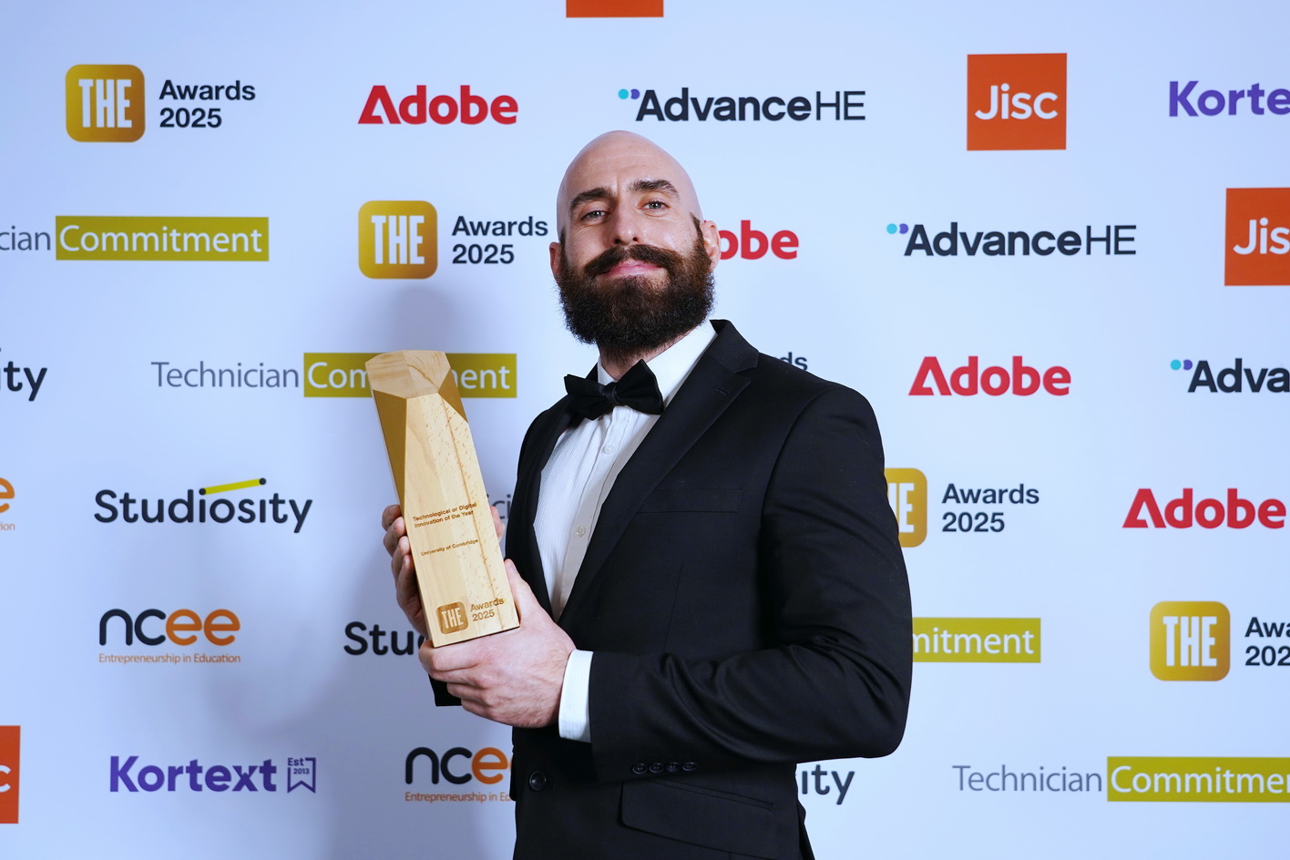 Business man with award at a corporate awards event against a step and repeat media wall in Edinburgh