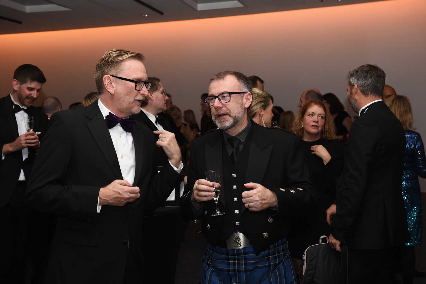 Professional photographer captures guests at a drinks reception as part of a business conference