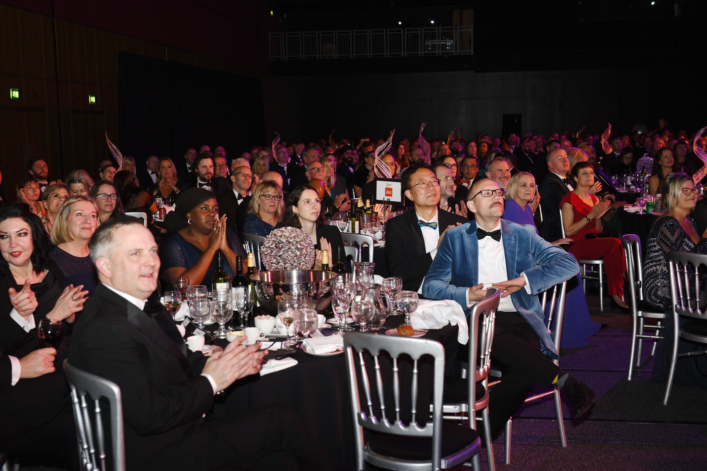 Awards guests at a table clapping during award ceremony