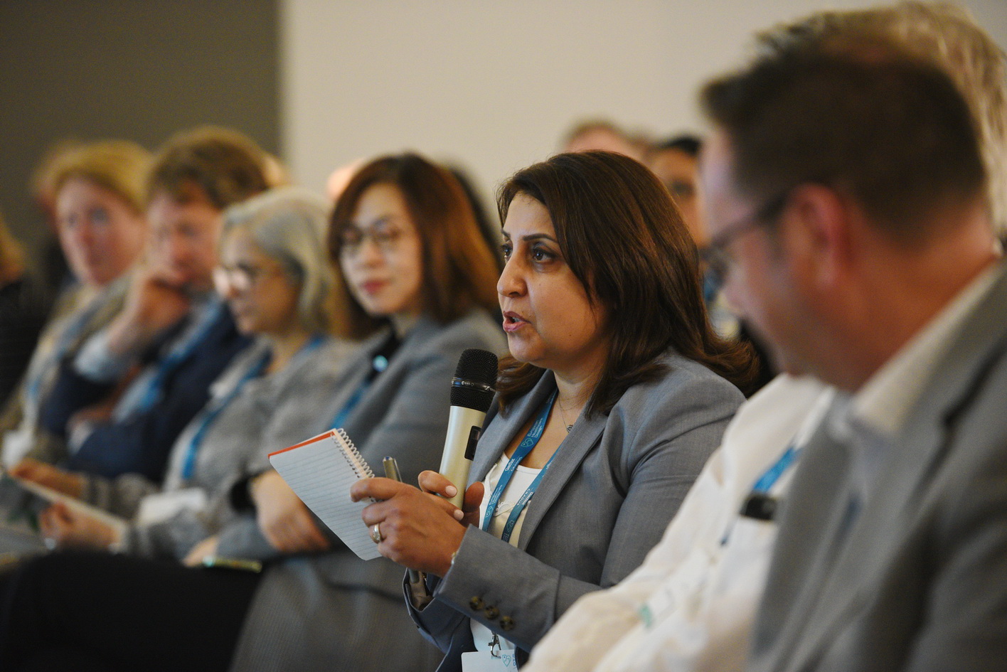 Audience members asking questions at a conference